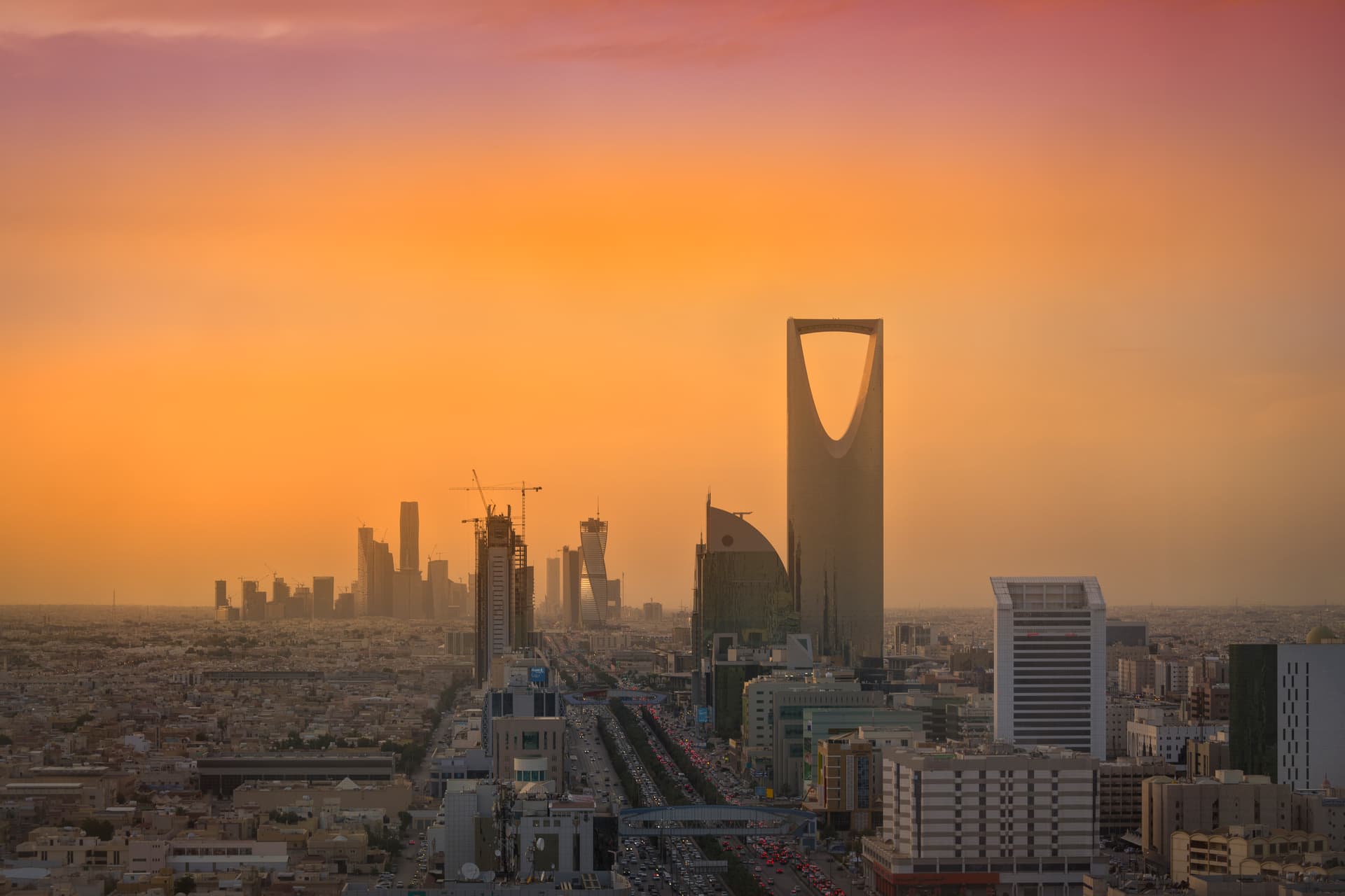 The skyline of Riyadh at sunset with Kingdom Centre and the towers of the financial district